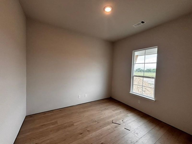 Neutral wall finishes and wood-finish flooring create a versatile interior space