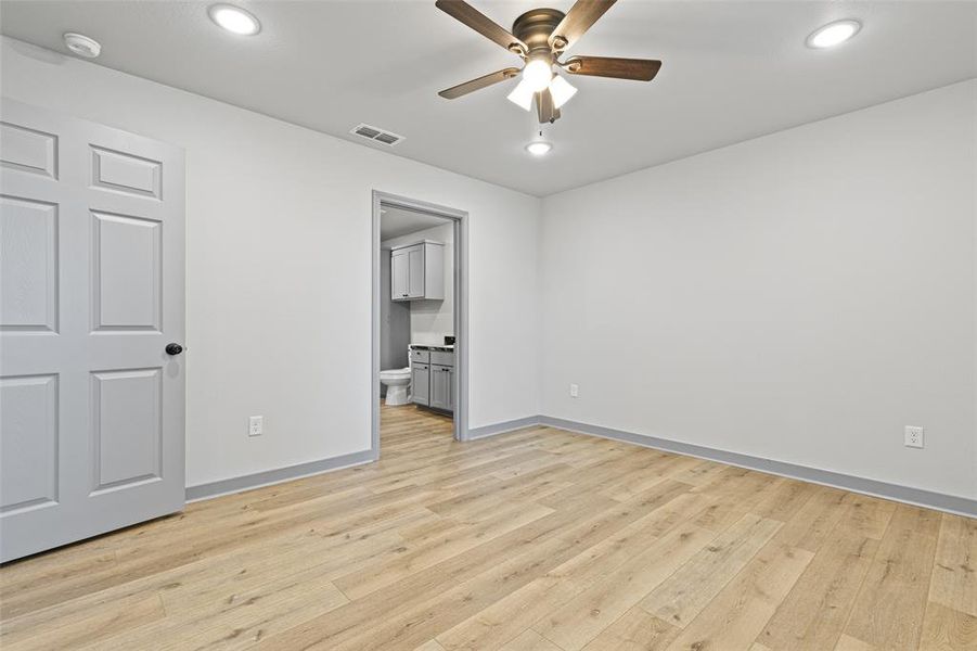Unfurnished bedroom featuring light wood-style flooring, recessed lighting, ceiling fan, and ensuite bathroom Unfurnished bedroom featuring light wood-style flooring, recessed lighting, ceiling fan, and ensuite bathroom