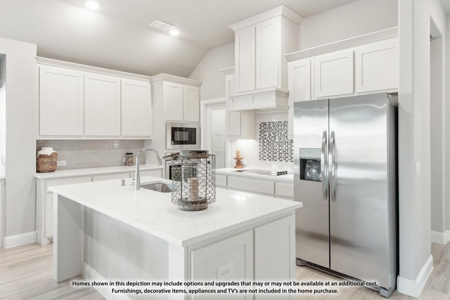 Kitchen with white cabinets, center island with sink, and stainless steel refrigerator