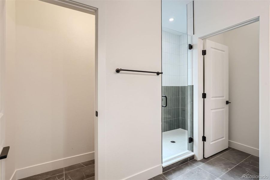 Primary bathroom with spacious shower, private water closet, and extra storage closet. (NOTE: This home has a darker color scheme. See finishes for details.)