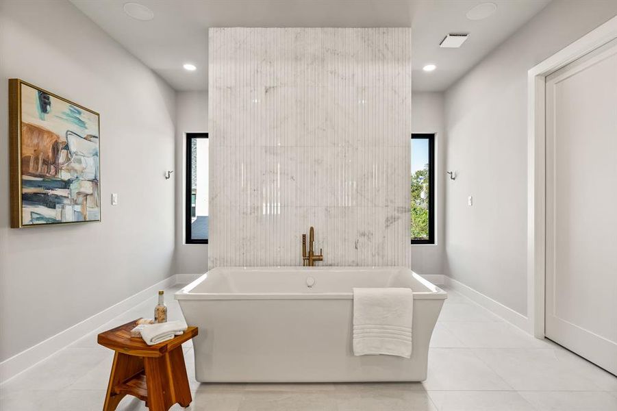 Bathroom with a soaking tub, light tile patterned flooring, and recessed lighting Bathroom with a soaking tub, light tile patterned flooring, and recessed lighting