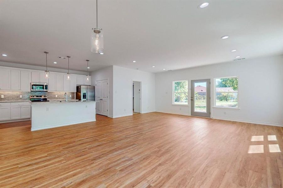 Unfurnished living room with light wood-type flooring and sink