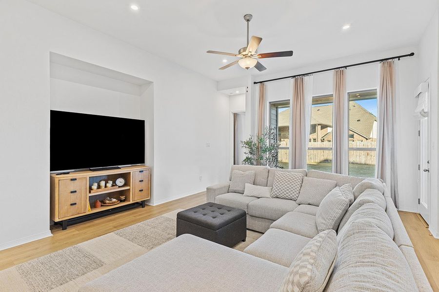 Living area with light wood-style flooring, recessed lighting, and a ceiling fan