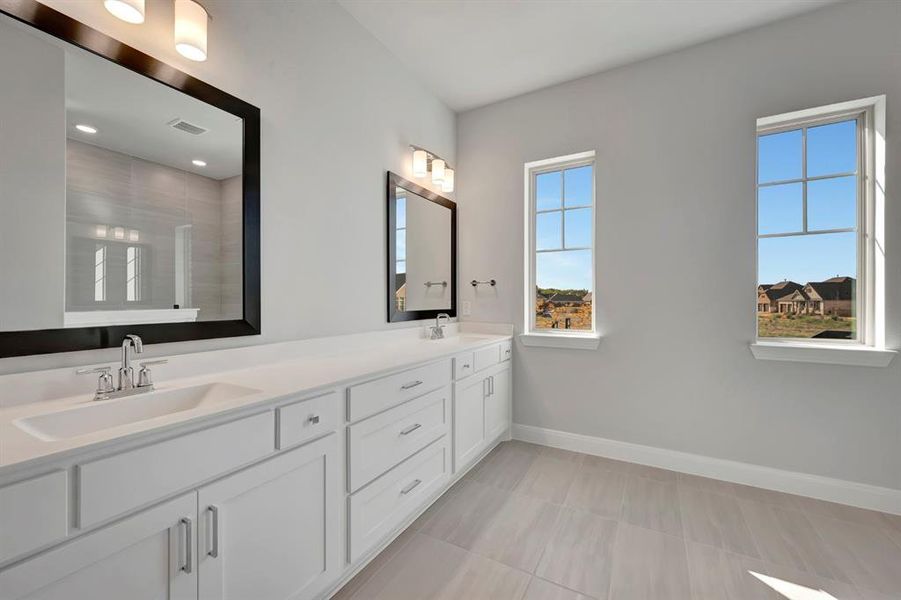 Full bathroom featuring double vanity and baseboards