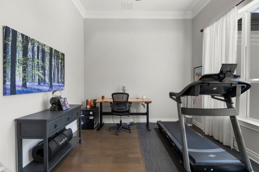 Well-lit room offering a versatile space for both productivity and exercise.