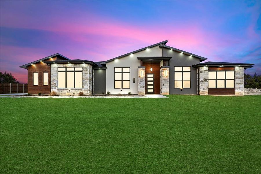 View of front of home with fence, a lawn, and stucco siding