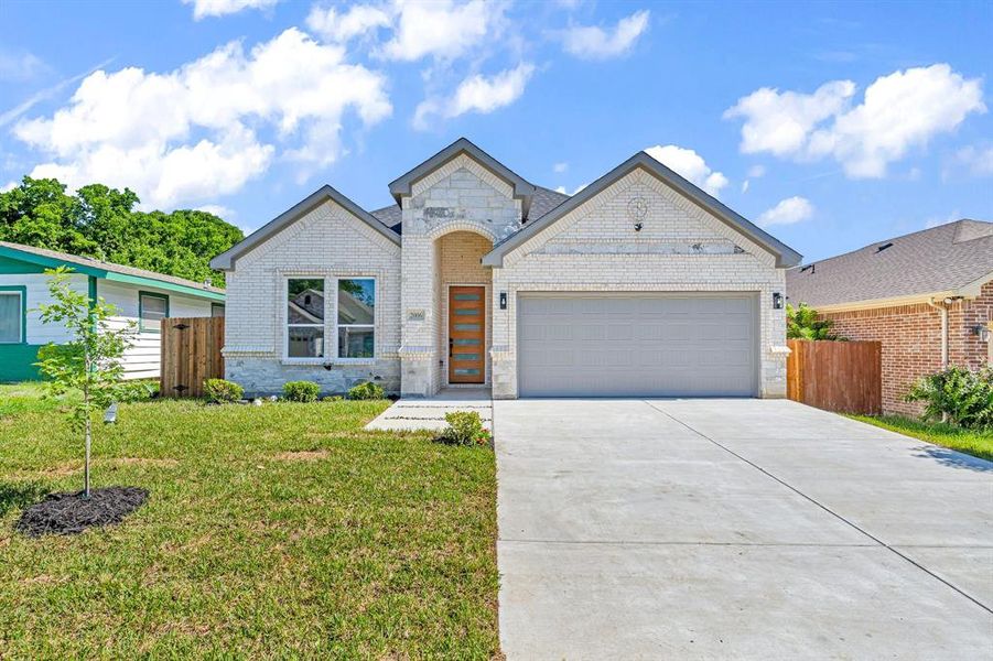 View of front facade featuring a garage and a front yard