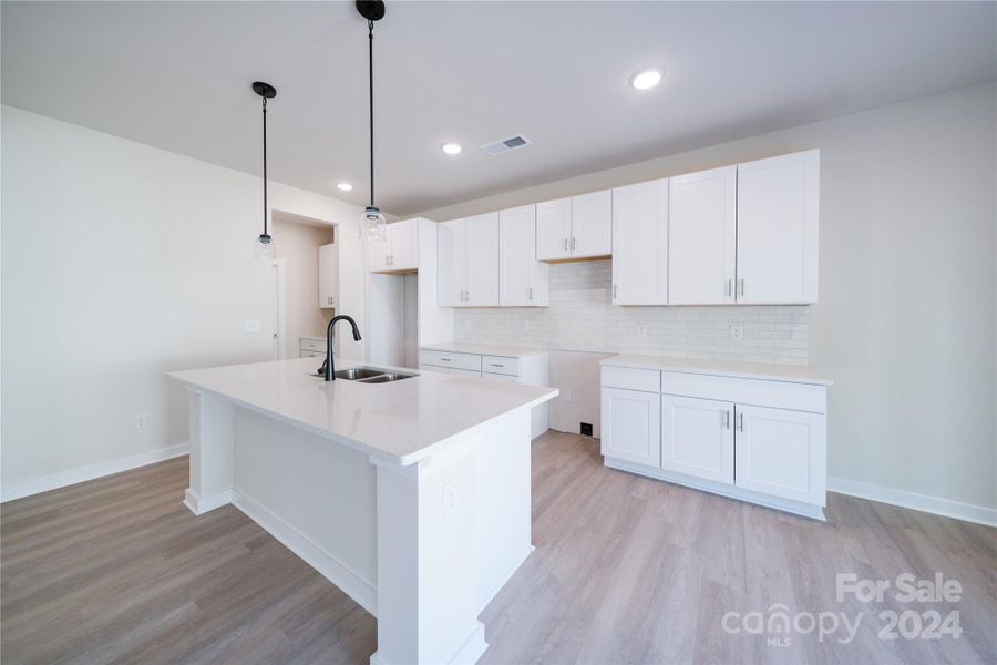 Kitchen features quartz countertops, upgraded cabinets, LVP flooring and stainless appliances