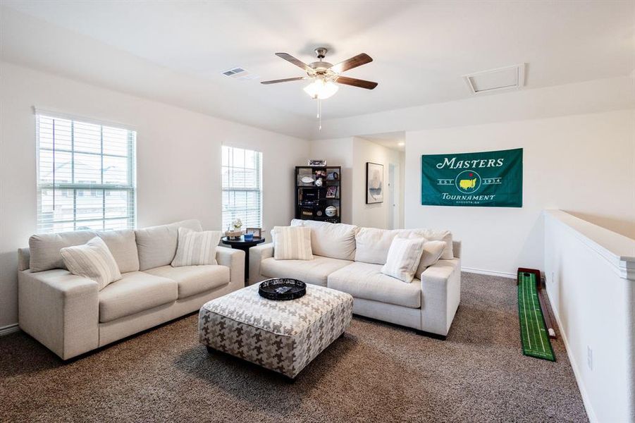 Carpeted living room with ceiling fan