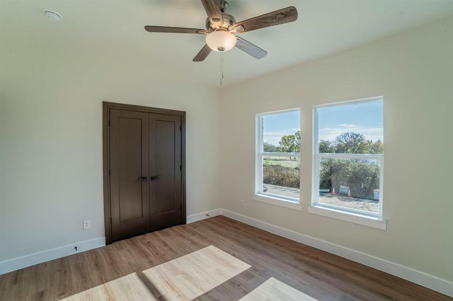 Unfurnished bedroom with a closet, wood finished floors, and ceiling fan Unfurnished bedroom with a closet, wood finished floors, and ceiling fan