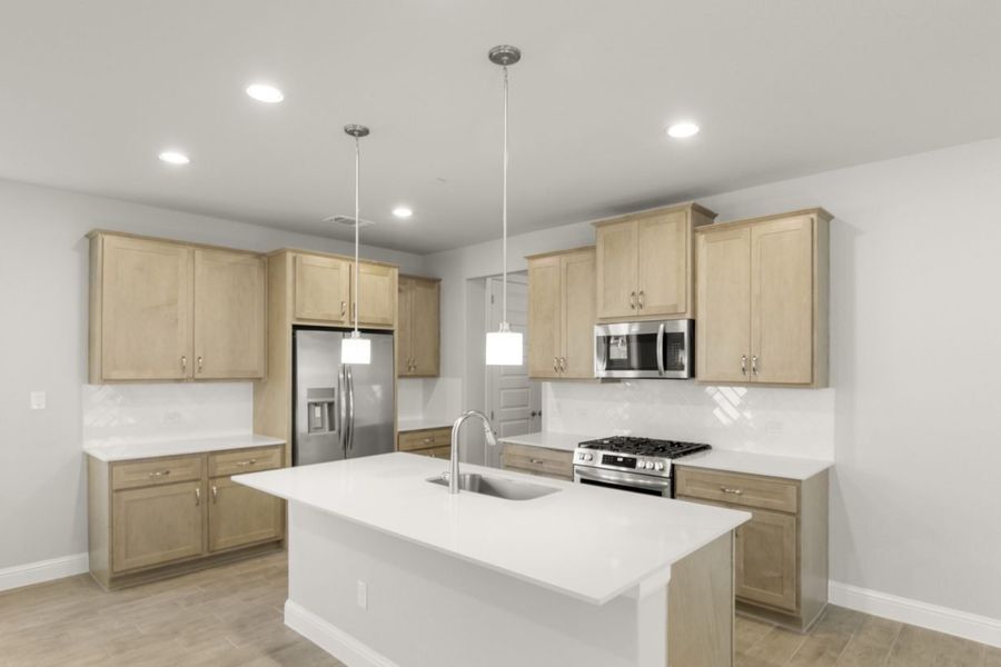 Image of a kitchen with a center island and light brown cabinetry with white backsplash and stainless steel appliances Image of a kitchen with a center island and light brown cabinetry with white backsplash and stainless steel appliances