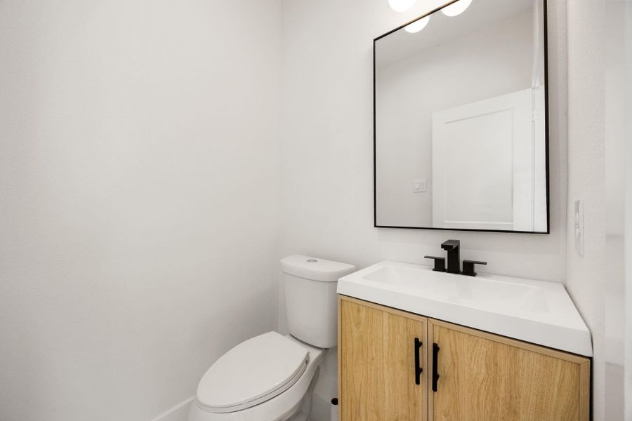 A conveniently located half bath featuring a clean, modern design, perfectly positioned for guests and everyday convenience.