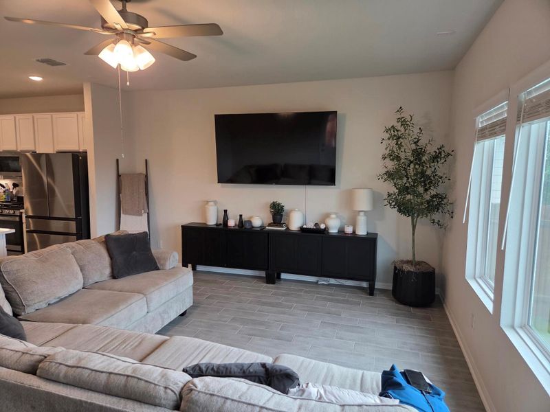 Open concept living area featuring light wood-finish tile flooring and recessed ceiling lights