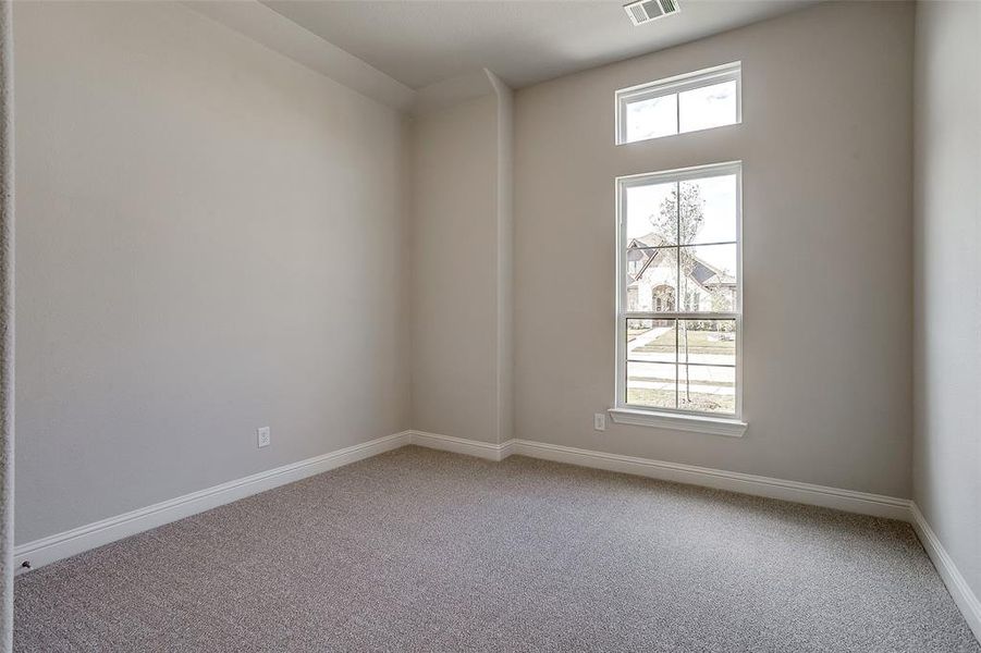 Spare room featuring carpet floors and plenty of natural light