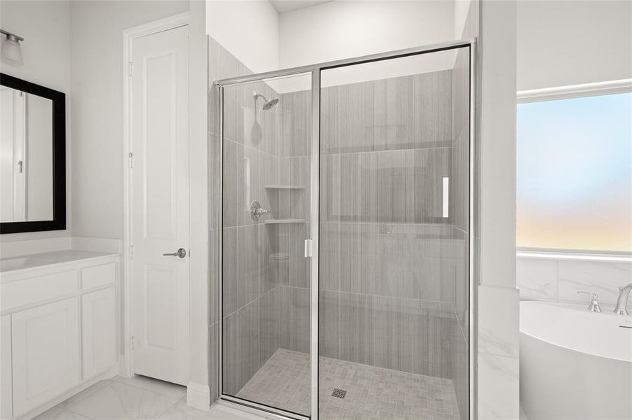 Bathroom with a soaking tub, vanity, light marble finish floors, and a shower stall