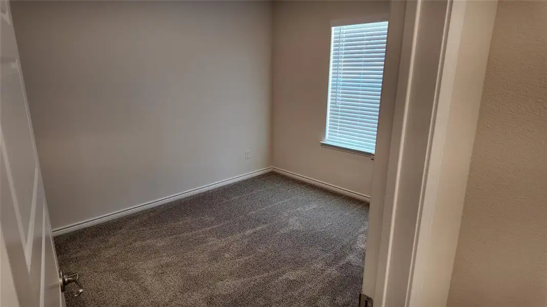 Unfurnished room with dark carpet and baseboards