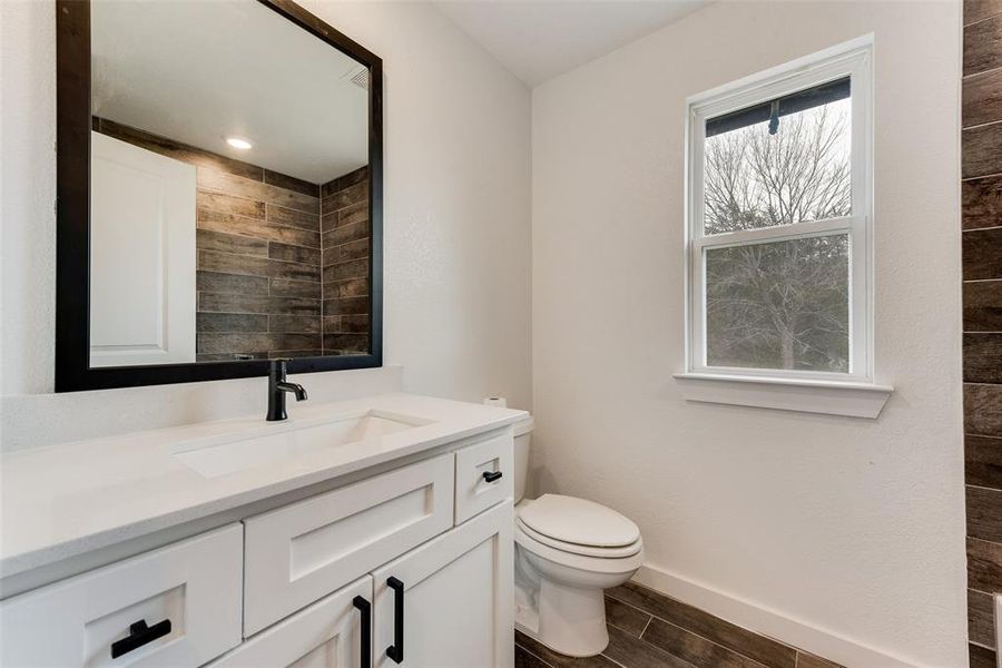 Bathroom with vanity, hardwood / wood-style flooring, and toilet