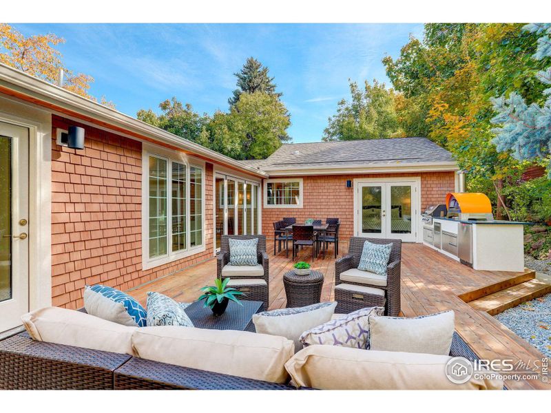 The private back yard patio features a custom built outdoor kitchen featuring Napoleon grill, refrigerator, trash and storage cabinets