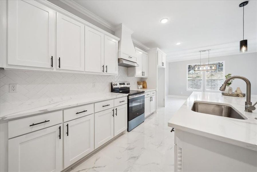 Kitchen with electric range, sink, and white cabinetry