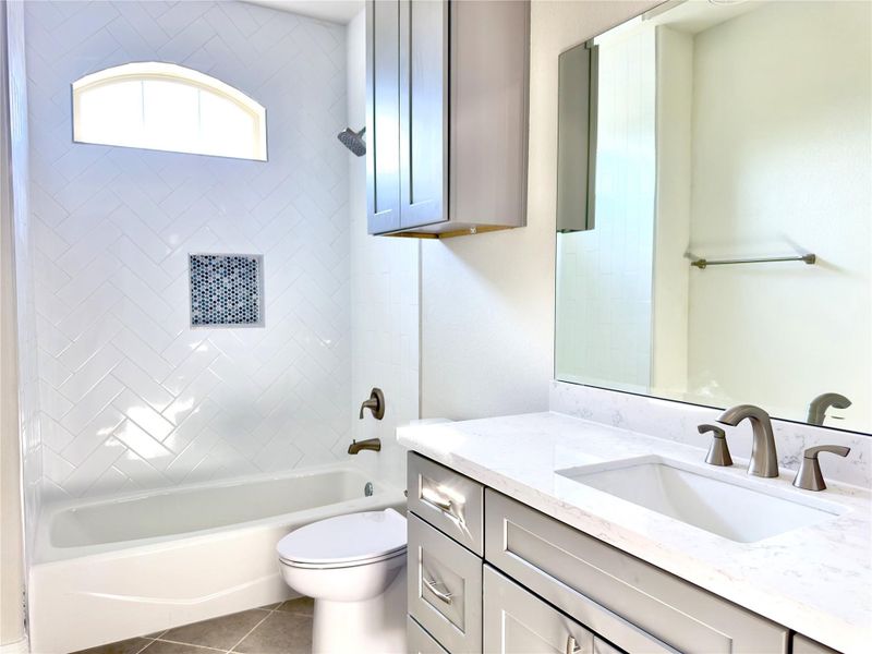 Bathroom featuring vanity, bathtub / shower combination, and tile patterned floors Bathroom featuring vanity, bathtub / shower combination, and tile patterned floors