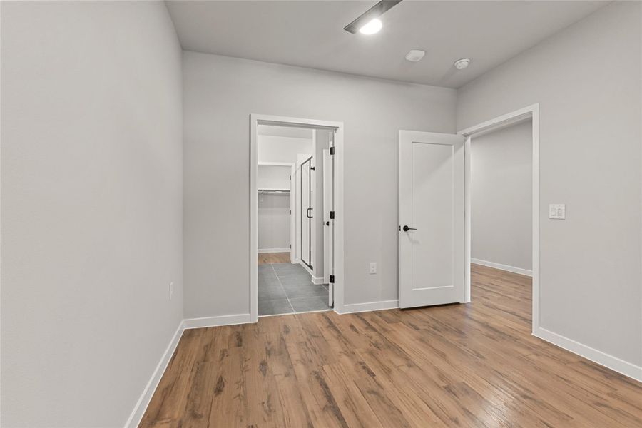 Unfurnished bedroom featuring a spacious closet and wood finished floors