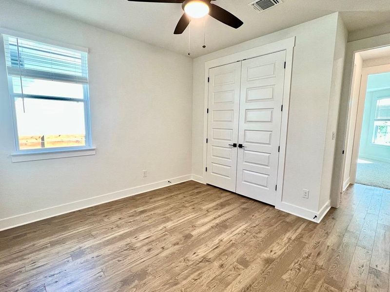 Unfurnished bedroom with light wood-type flooring, a closet, and ceiling fan