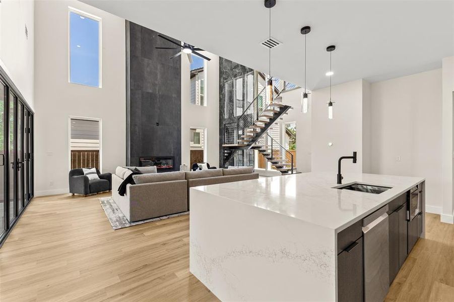 Open-concept living space with soaring ceilings and light wood-finish flooring