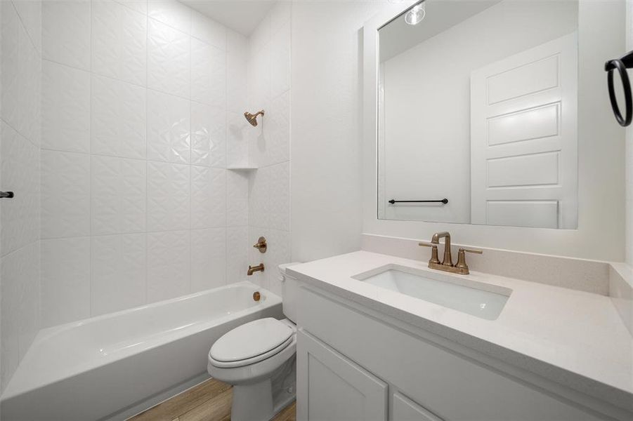 Bathroom featuring vanity, bathtub / shower combination, and wood finished floors