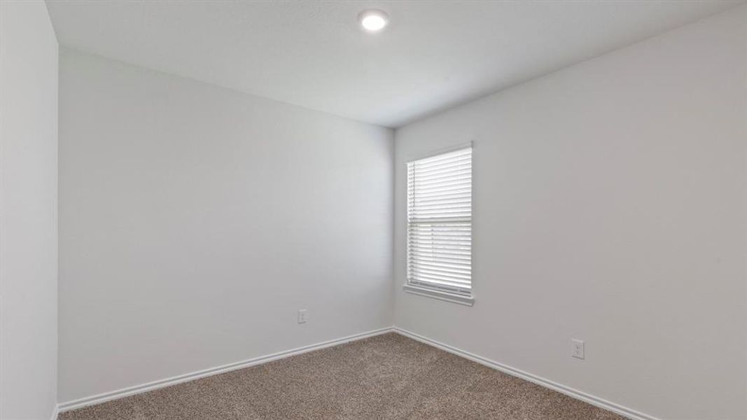 Carpeted room featuring a single window with blinds, recessed ceiling lighting, and light-colored wall paint