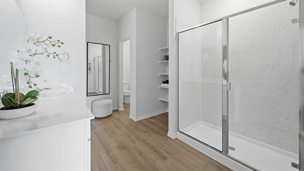 Bathroom with double vanity, a stall shower, and light wood-style floors Bathroom with double vanity, a stall shower, and light wood-style floors