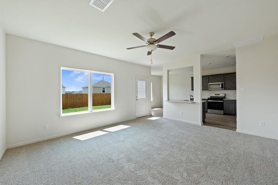 Living room with ceiling fan and light colored carpet