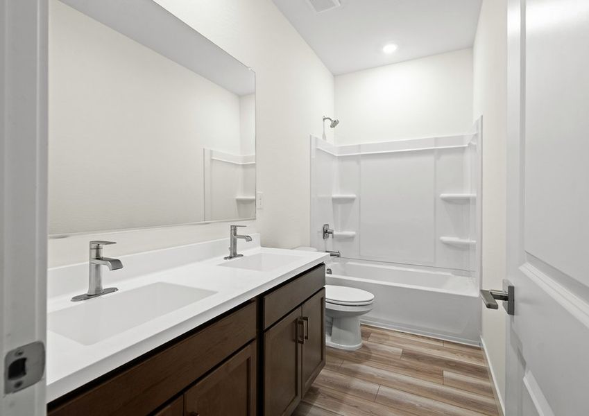 This secondary bathroom features dual-vanity sinks.