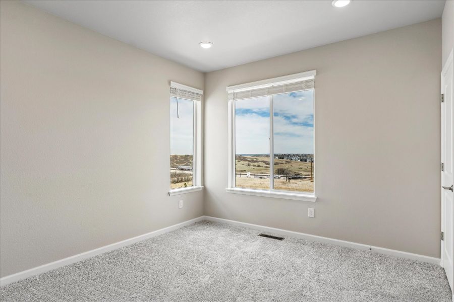 A room with a window and a rug.