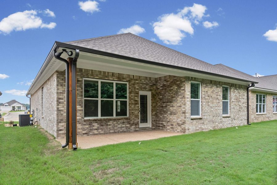 Brick exterior with a covered patio and concrete flooring Brick exterior with a covered patio and concrete flooring