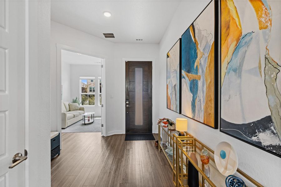Entryway with baseboards, visible vents, and wood finished floors