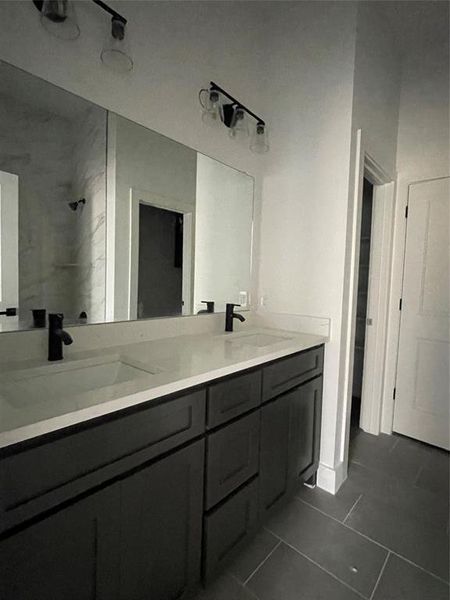 Bathroom featuring tile patterned floors, vanity, and tiled shower