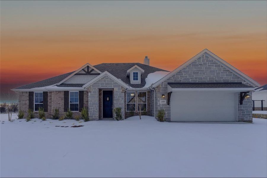 Craftsman house featuring stone siding, a chimney, and an attached garage Craftsman house featuring stone siding, a chimney, and an attached garage