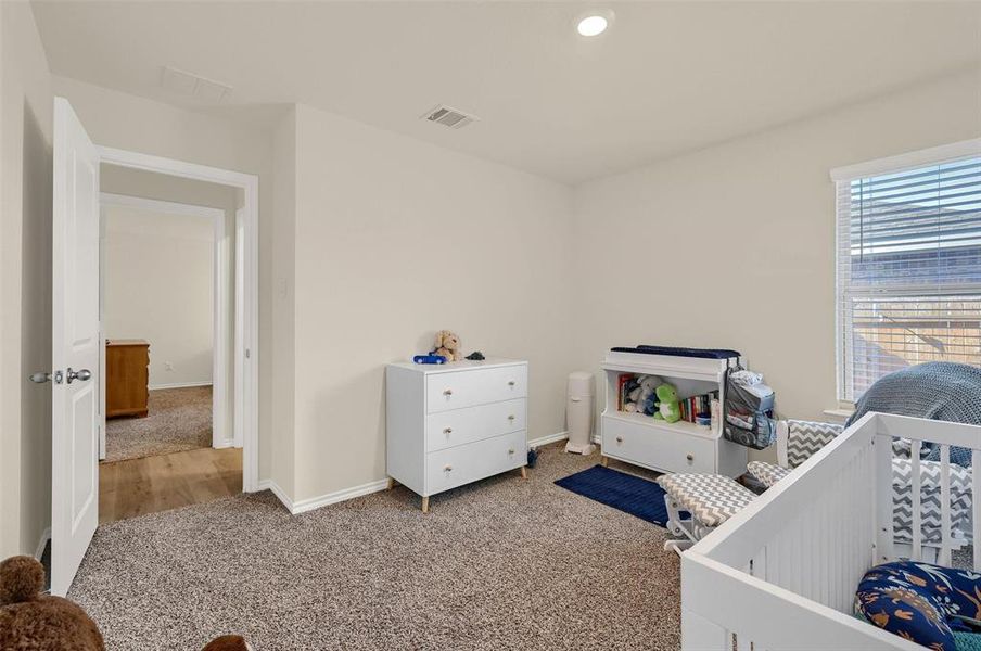 Carpeted bedroom with a crib