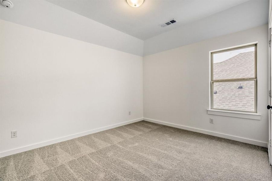 Spare room with light carpet and baseboards