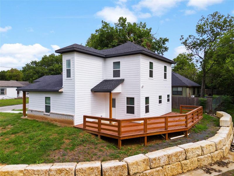 `Rear view of house with a wooden deck and a shingled roof `Rear view of house with a wooden deck and a shingled roof