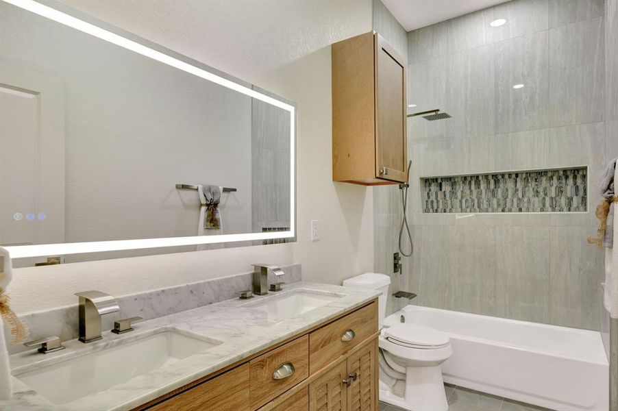 Bathroom featuring a double vanity with stone countertop and integrated sinks Bathroom featuring a double vanity with stone countertop and integrated sinks