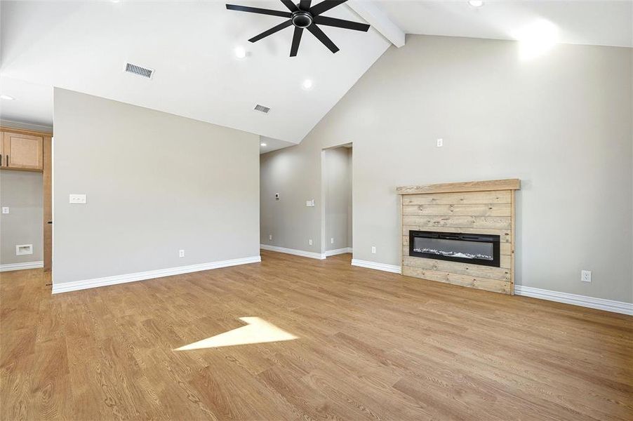 Unfurnished living room featuring light wood-style floors, a ceiling fan, a glass covered fireplace, and recessed lighting Unfurnished living room featuring light wood-style floors, a ceiling fan, a glass covered fireplace, and recessed lighting
