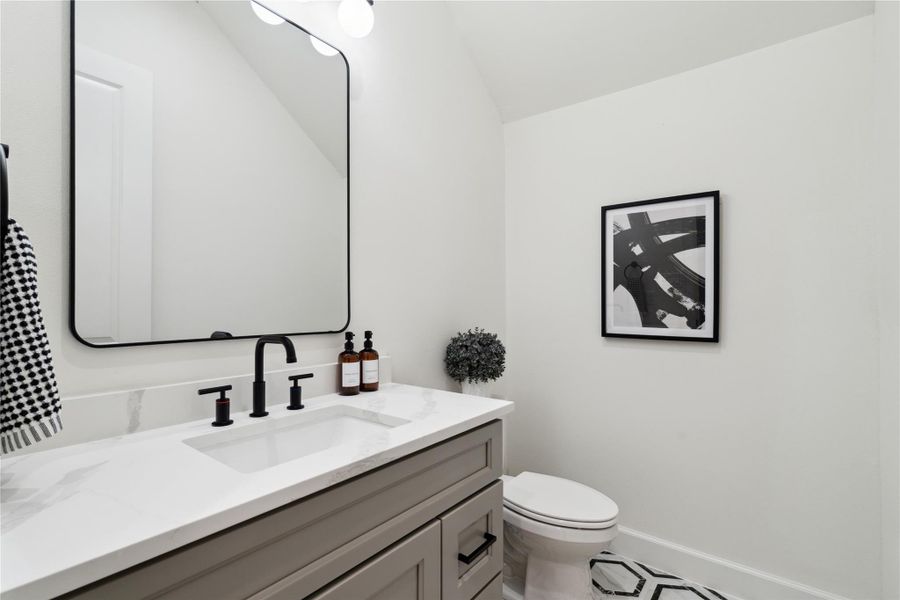 A generously sized powder room retreat features a clean, contemporary aesthetic. With sleek design and thoughtful details, it offers a luxurious experience for guests, blending style and comfort.