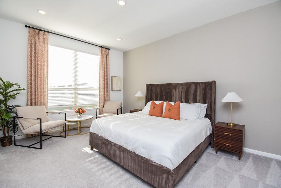 A luxurious bedroom suite with soft tones, stylish furnishings, and ample natural light.
