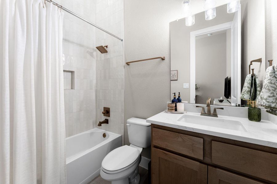 Full bathroom featuring a single vanity with wood-finish cabinetry and a white countertop