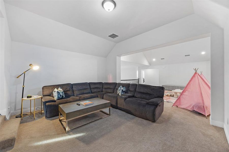 Living room featuring vaulted ceiling, light colored carpet, and recessed lighting