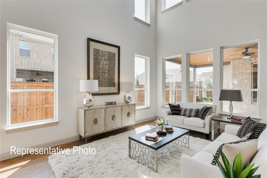 Living room featuring a towering ceiling, ceiling fan, and hardwood / wood-style floors