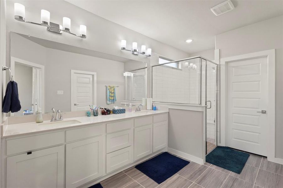 Full bath with a shower stall and double vanity