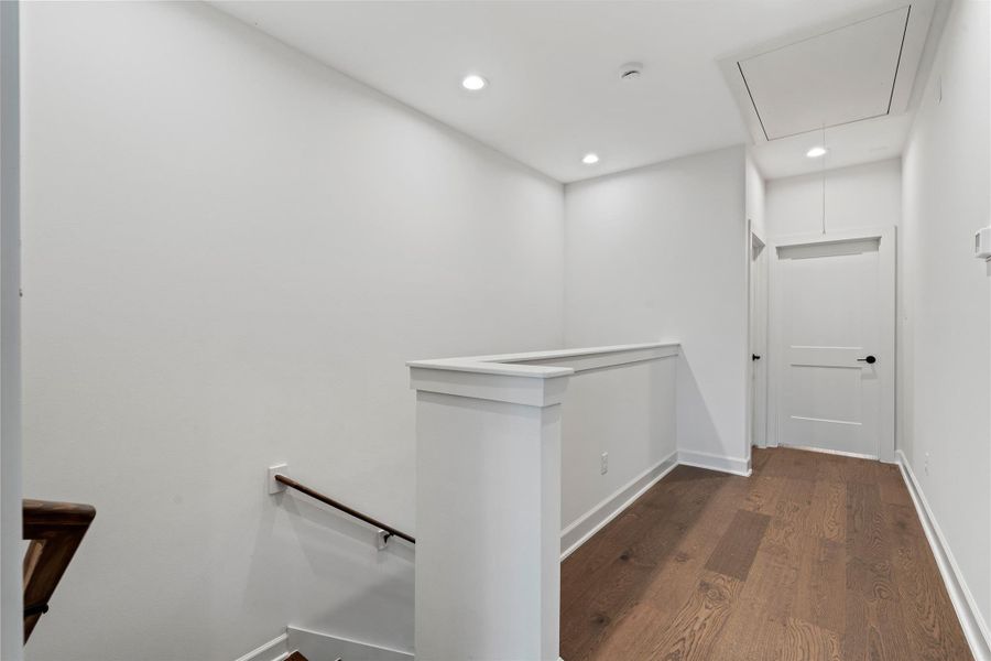 A view of the third-floor hallway that connects the primary bedroom, secondary bedroom, and the laundry room.
