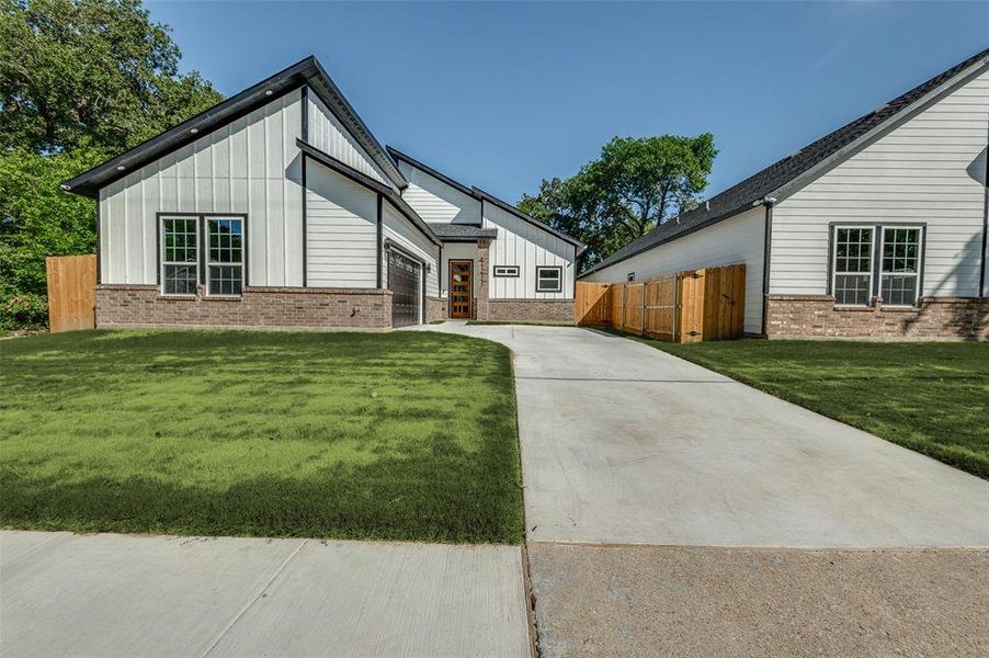 View of front of property with driveway, board and batten siding, brick siding, and a garage View of front of property with driveway, board and batten siding, brick siding, and a garage